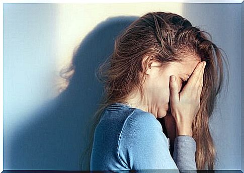 Crying woman with hands covering her eyes.