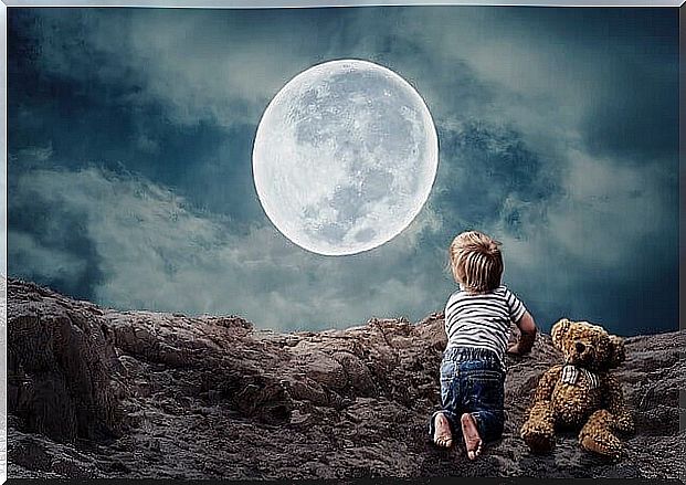 little boy in front of the full moon