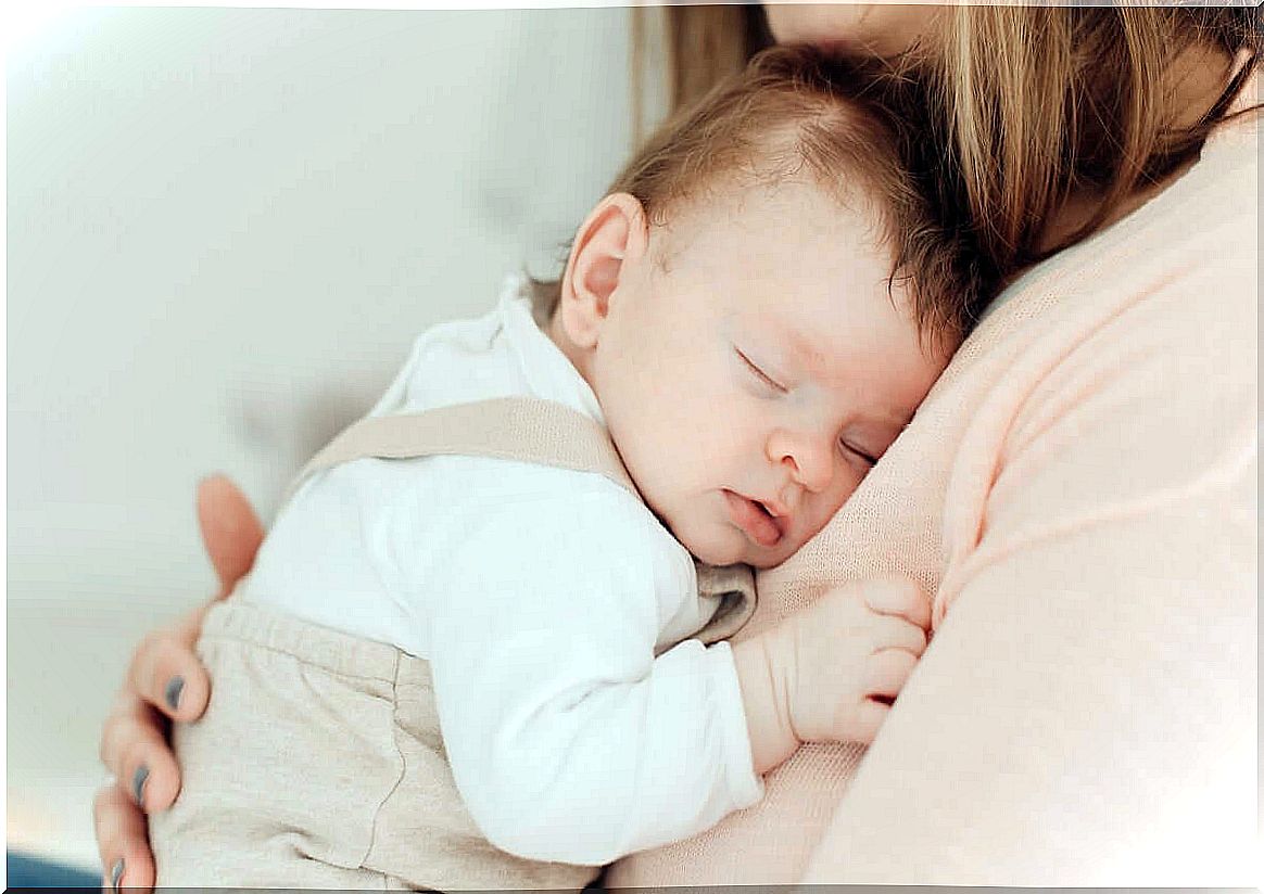 baby sleeping on mother's lap