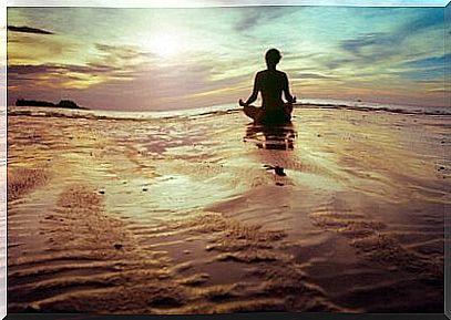 woman meditating on the beach