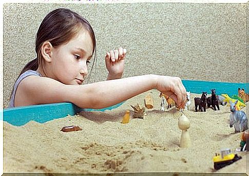 girl playing with toys in the sand