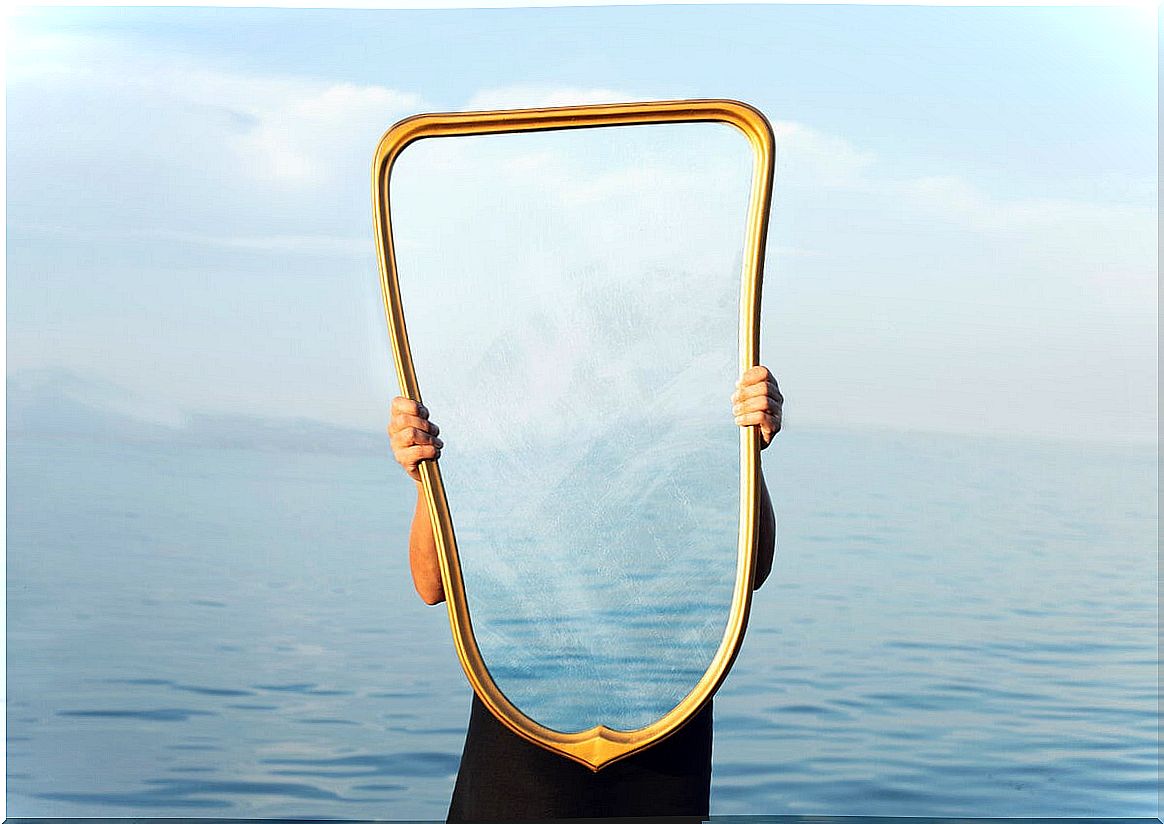 person holding mirror at sea